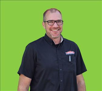 SERVPRO employee in front of green background