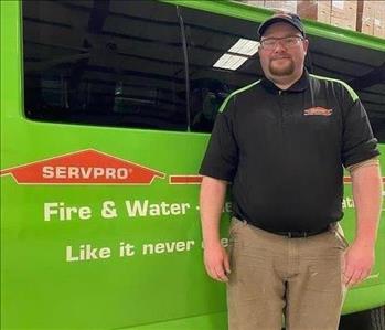 Employee smiling in front of SERVPRO truck 