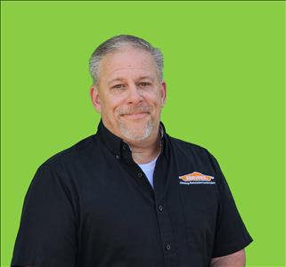 SERVPRO employee in front of green background