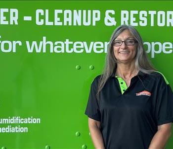 Female employee smiling in front of SERVPRO truck 